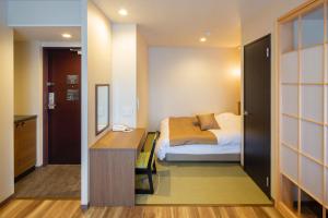 伊万里市Hotel Imari Aioibashi Bettei的一间卧室配有一张床和一张书桌