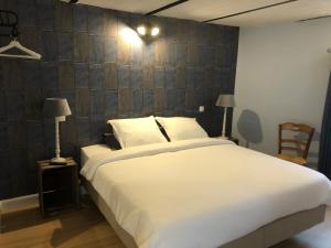 屈尔内Cuerne bed&breakfast的卧室配有一张白色大床和木墙