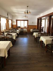 伊钦Turistická chata Prachov的一间设有白色桌椅的用餐室