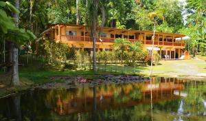 卡纳内亚Pousada Recanto do Morro的一座位于大楼前的带池塘的度假村