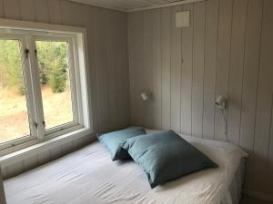 伯Gårdsturisme Sønstebø的一间卧室配有带两个枕头的床和窗户