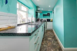 巴姆博格Host & Stay - Poppy Cottage的厨房设有蓝色的墙壁和水槽