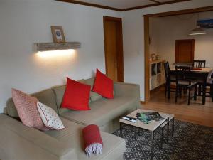 格施塔德Apartment Oehrli by Interhome的客厅配有带红色枕头的沙发