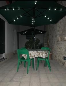 阿纳卡普里Hedera Capri B&B的黑色伞下的绿色桌椅