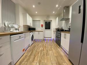 泰恩河畔纽卡斯尔Heaton Park Road Professional Lets的厨房铺有木地板,配有白色橱柜。