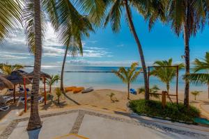 阿文图拉斯港Puerto Aventuras Hotel & Beach Club的棕榈树度假村享有海滩美景
