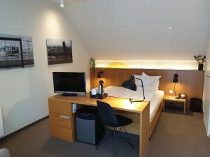 汉堡鲍尔斯公园酒店的一间卧室配有一张床和一张带电脑的书桌