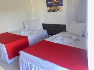 嘎林海斯港Nannai Beira Mar Porto de Galinha 207的两张睡床彼此相邻,位于一个房间里