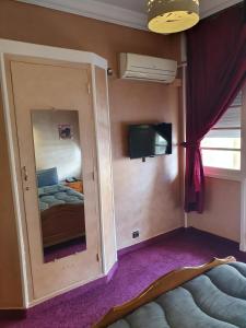 盖尼特拉Ambassy Hotel的小房间设有镜子和一张床