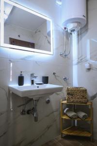新帕扎尔Apartman Filip的浴室设有白色水槽和镜子