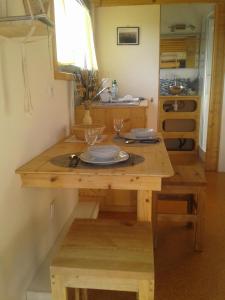 LanmodezTiny house sur la Presqu'île Sauvage的厨房配有木桌和2杯玻璃杯