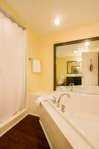 伍德斯托克克德龙山谷宾馆的一间带浴缸和大镜子的浴室
