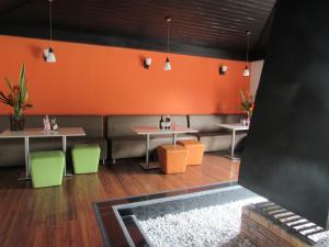 圣奥古斯丁Hotel Yalconia的一间设有两张桌子和椅子的餐厅,拥有橙色的墙壁