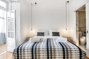 里斯本Saldanha Pool & Garden的白色卧室,配有一张带 ⁇ 子毯子的床