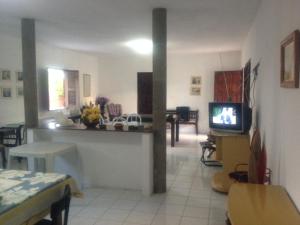 阿拉卡蒂Repouso do Mar Residence的带电视的客厅和用餐室