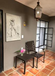 阿吉吉克Casa del Sol Inn的一间房间,配有椅子和一张桌子,一张图片