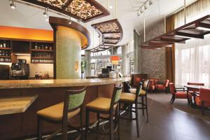 里弗赛德滨江市区凯悦嘉轩酒店的餐厅内的酒吧,配有桌椅
