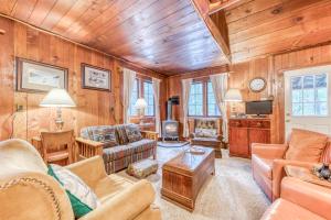 韦尔奇Old Smokey Cabin的客厅设有木镶板墙和天花板