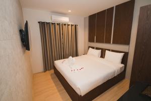 清迈Y智能酒店的一间卧室配有一张带白色床单的大床