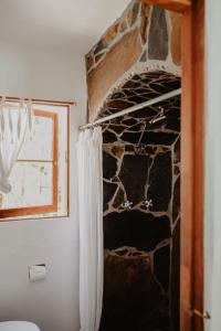 棕榈泉考卡酒店的浴室设有石墙和淋浴帘