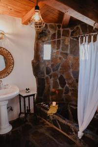 棕榈泉考卡酒店的浴室设有石质淋浴帘和水槽