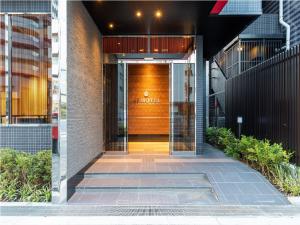 东京Ai Hotel Keikyu Kamata的门上标有标志的建筑物入口