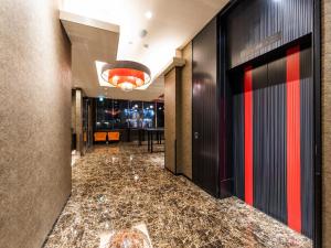 东京Ai Hotel Keikyu Kamata的酒店大堂的走廊,铺有大理石地板