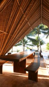 毛梅雷Eco dive resort Alycastre的一张大木桌,坐在屋顶下