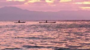 毛梅雷Eco dive resort Alycastre的日落时分两人在水上乘船