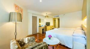 乔木提恩海滩乔木提恩棕榈滩度假酒店 - SHA Extra Plus的酒店客房配有床、沙发和桌子。
