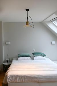 Horebeke克赛乐59住宿加早餐酒店的卧室配有带绿色枕头的白色床