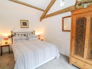 Saint NeotTreverbyn Smithy的一间卧室配有一张床和一个木制橱柜