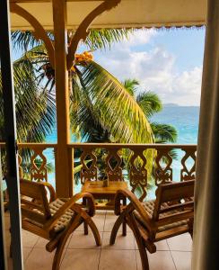 拉迪格岛帕特坦村酒店的阳台配有两把椅子,享有海景。