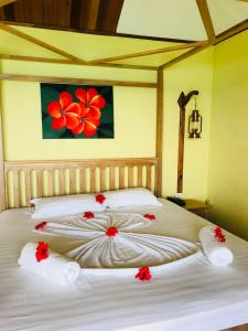 拉迪格岛帕特坦村酒店的一间卧室配有两张红色鲜花的床。