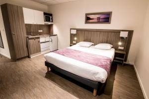 泰昂维泰昂维郁金香公寓式酒店的酒店客房带一张床和一个厨房