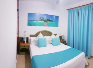 卡兰博希Apartamentos Costa Menorca的一间卧室配有一张带蓝色窗帘的大床
