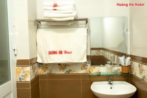 绥和市Hoàng Hà Hotel的浴室设有水槽,毛巾挂在架子上