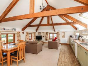 大托灵顿Lundy View Cottage的厨房和带木梁的客厅