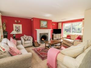 埃文河畔斯特拉特福Highcroft的客厅设有红色的墙壁和壁炉
