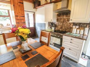 PenningtonHorrace Farm Cottage的厨房配有桌子和花瓶