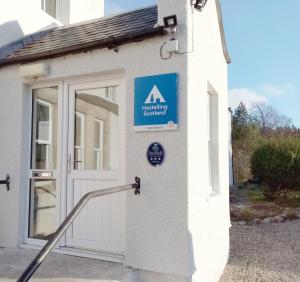 Loch MorlichCairngorm Lodge Youth Hostel的建筑物一侧有门的标志