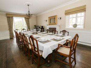 Ifton HeathPlas Yolyn的一间大型用餐室,配有白色的桌子和椅子
