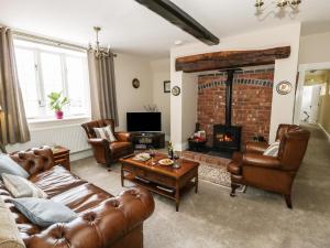 Ifton HeathPlas Yolyn的客厅配有皮革家具和壁炉