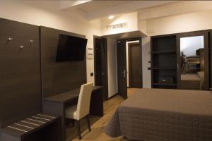 雷卡纳蒂Hotel Ristorante Da Tonino的一间卧室配有一张床、一张书桌和一台电视