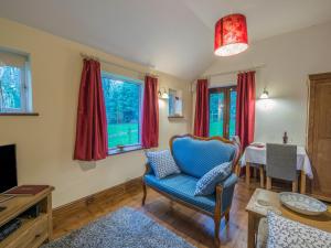 彻奇斯特雷顿Woodpeckers Cottage的客厅配有蓝色椅子和桌子