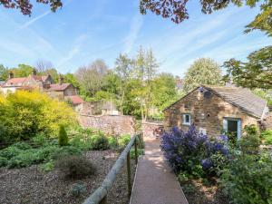 德朗菲尔德Vale Barn的一座花园,花园内设有石屋和小径