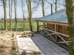 TrelystanValley View Lodge的小木屋设有野餐桌和长凳