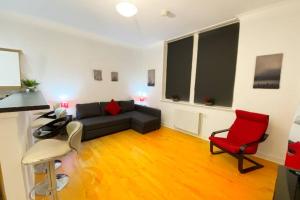 格拉斯哥Cozy Nights - Ibrox Street的客厅配有黑色沙发和红色椅子