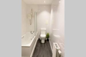 格拉斯哥Cozy Nights - Ibrox Street的白色的浴室设有浴缸和卫生间。