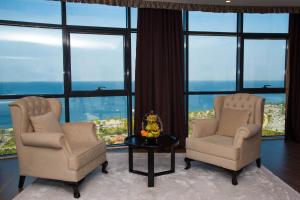 巴统Euphoria Batumi Convention & Casino Hotel的带窗户的客房内配有两把椅子和一张桌子